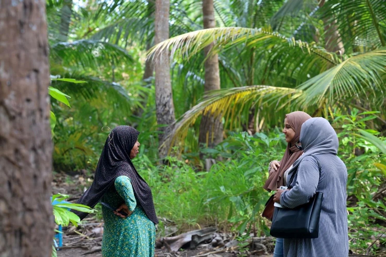 2 adults talking to an elderly person 