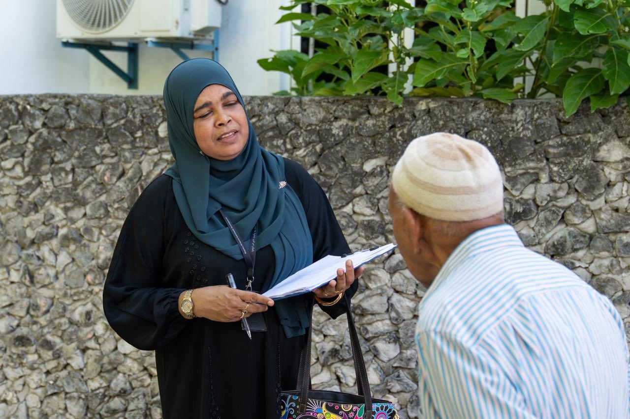 Ministry staff from haalu kihineh program talking to an elderly man on the road